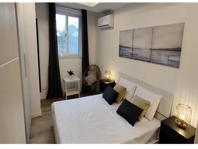 a hotel room with a bed, table, and a mirror