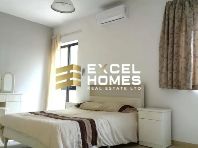 a bed with a white bedspread and a white wall