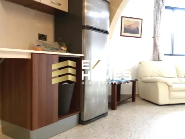 a kitchen with a refrigerator, stove, and a table