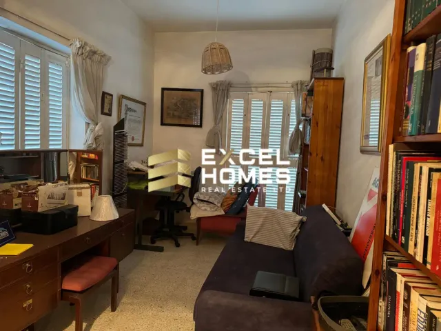 a living room with a desk and a chair