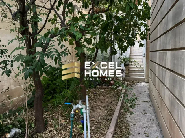 a fence with a tree and a building