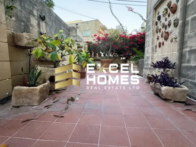 a small garden with a large stone wall