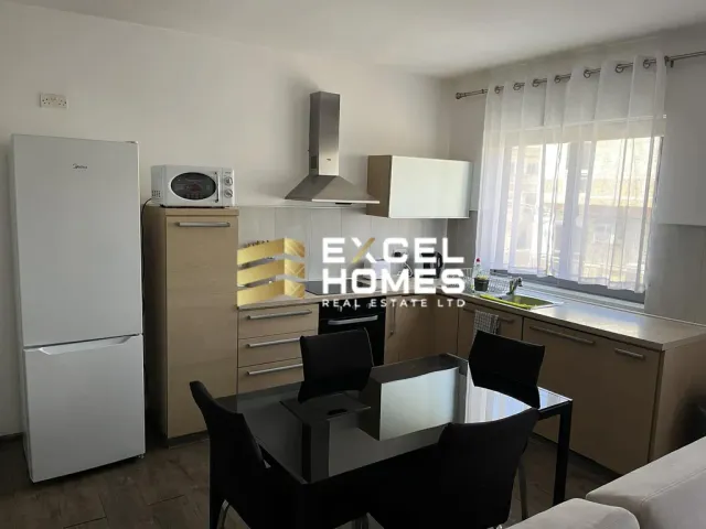 a kitchen with a table, refrigerator, and a microwave