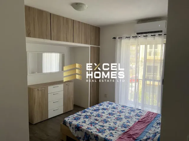 a bedroom with a bed, desk, and a window