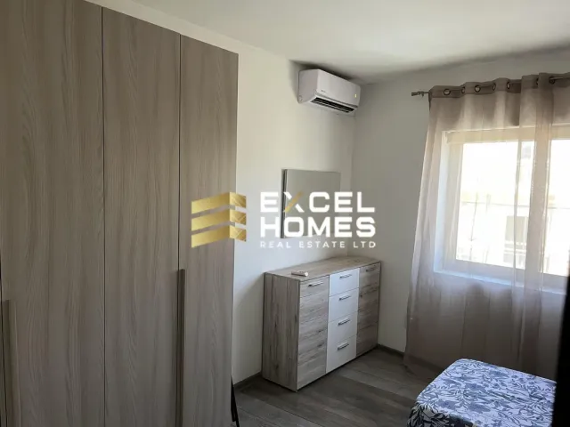 a white refrigerator in a bedroom with a white wall