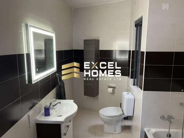 a bathroom with a toilet, sink, and mirror