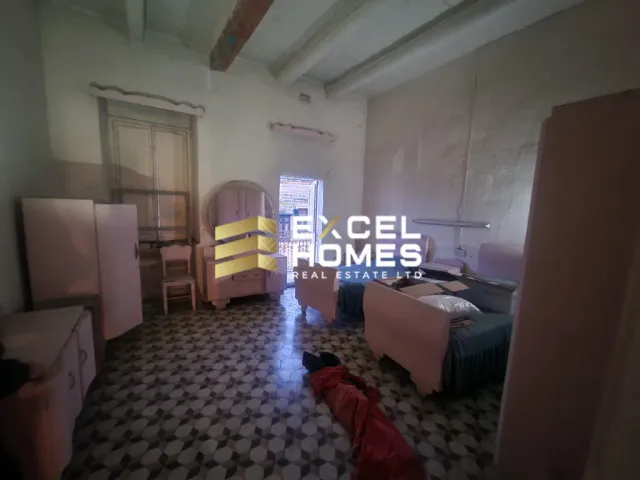 a room with a bed, a chair, and a tv