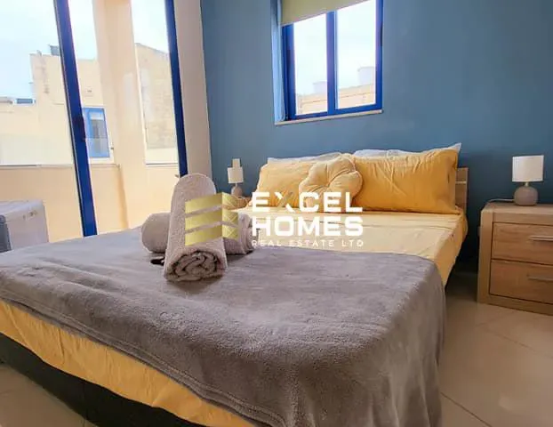 a bed with a white bedspread and a blue comforter