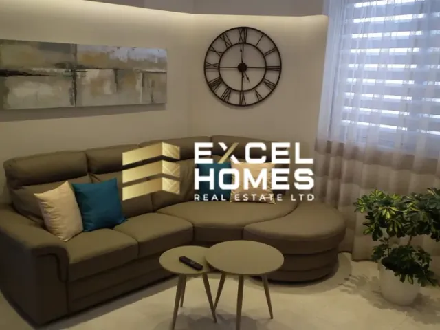 a living room with a couch, coffee table and a clock