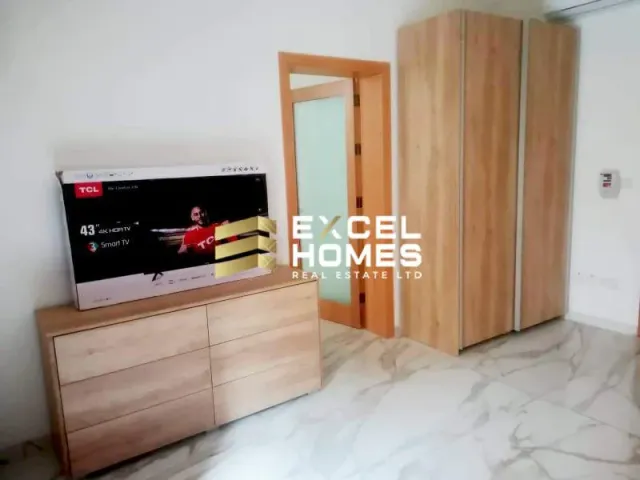 a television is on in a room with a wooden floor