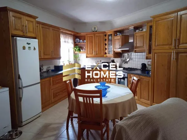 a kitchen with a table and chairs and a refrigerator
