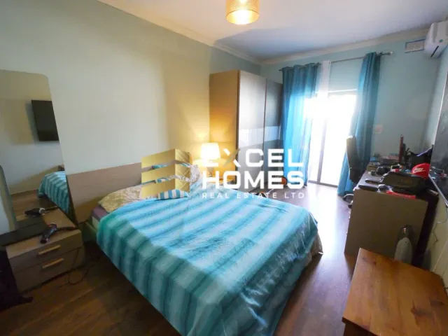 a bedroom with a bed, desk, and chairs