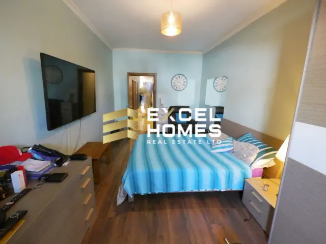 a bedroom with a bed, desk, and a window