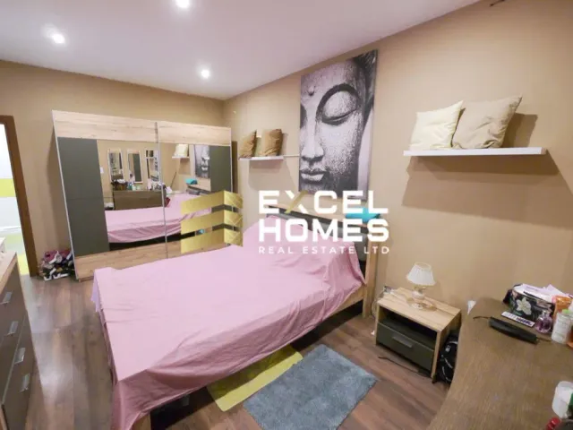 a bedroom with a bed, desk, and a mirror