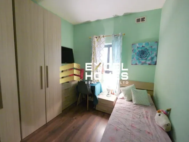 a bedroom with a bed, a dresser, and a window