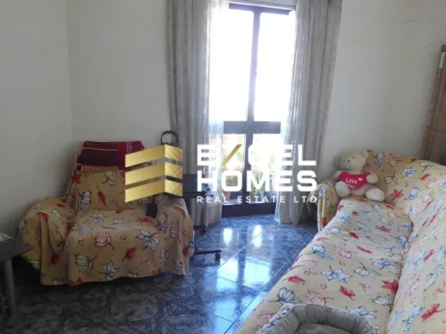 a bedroom with a bed, chair, and a window