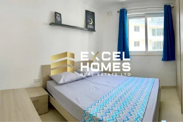 a bed with a white bedspread and a blue comforter