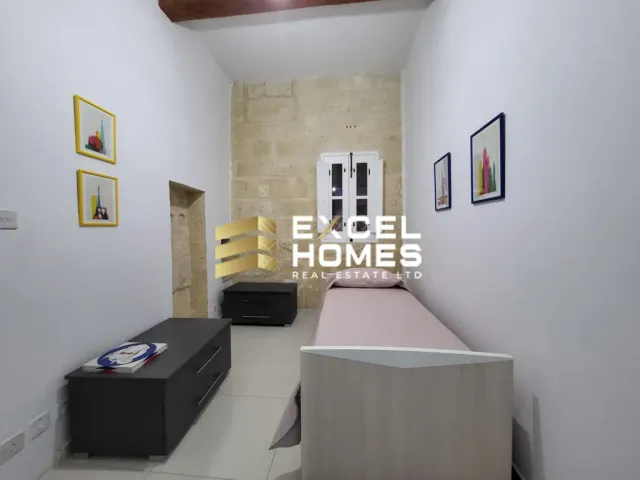 a room with a large bed and a painting on the wall