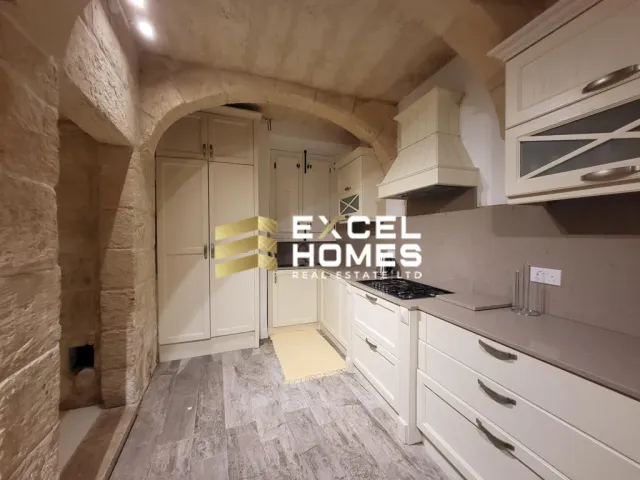 a kitchen with a sink, stove, and a window