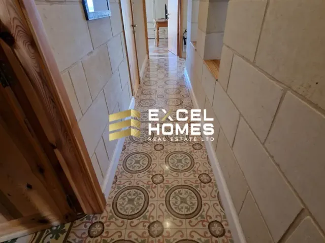 a hallway with a white tile floor and a black and white tile floor
