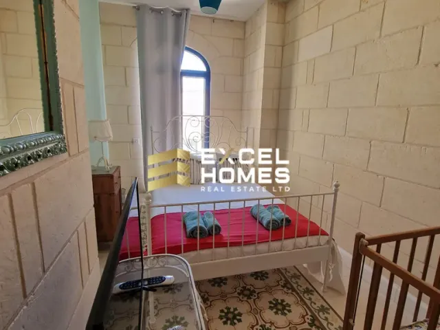 a bed with a red blanket and a blue curtain