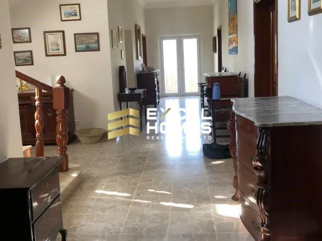 a kitchen with a refrigerator, stove, and a television