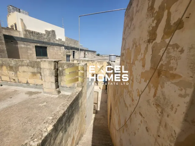 a stone wall with a stone wall and a building 