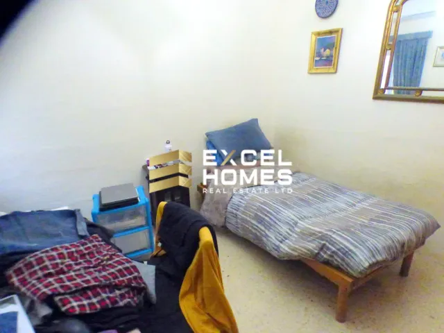 a bedroom with a bed, desk, and a chair 