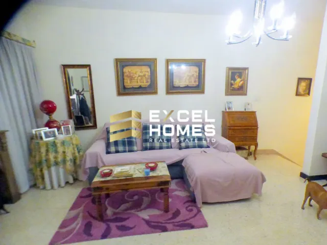 a bedroom with a bed, table, and a painting on the wall 