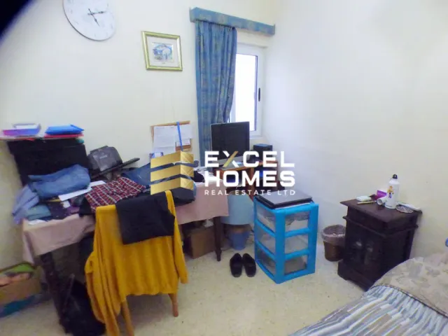 a room with a bed, a desk, and a cat 