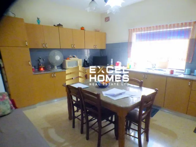 a kitchen with a table and chairs and a refrigerator 