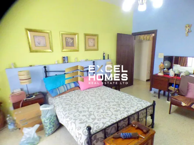 a bedroom with a bed, desk, and a dresser 