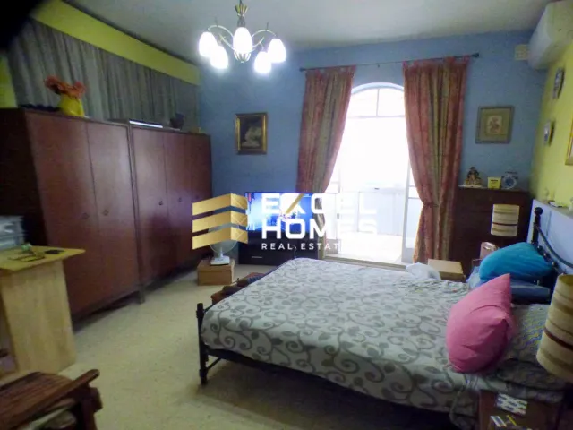 a bedroom with a bed, desk, and a lamp 