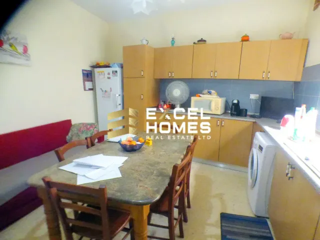 a kitchen with a table and chairs and a refrigerator 