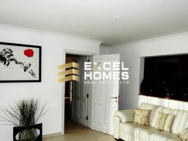 a living room with a couch, coffee table and a bookcase