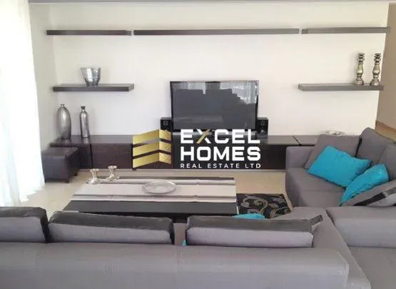 a living room with a couch, coffee table, and a bookcase