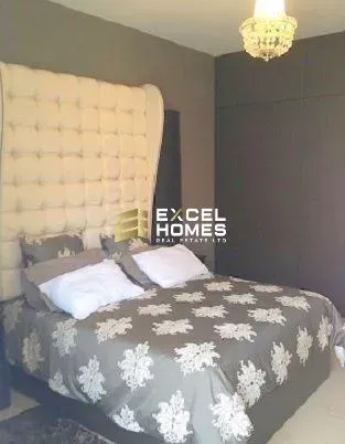 a bed with a white blanket and a blue comforter