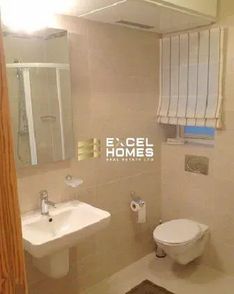 a bathroom with a toilet, sink, and mirror