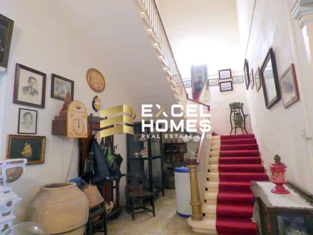 a room with a wall of pictures and a clock