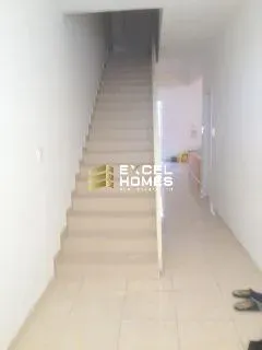 a hallway with a white wall and a black and white floor