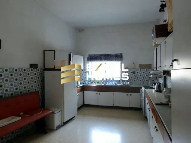 a kitchen with a refrigerator, stove, sink and a window