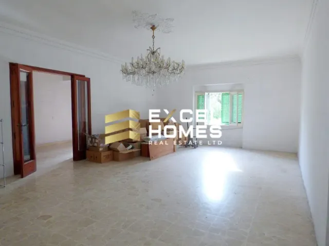 a room with a couch, a table and a window