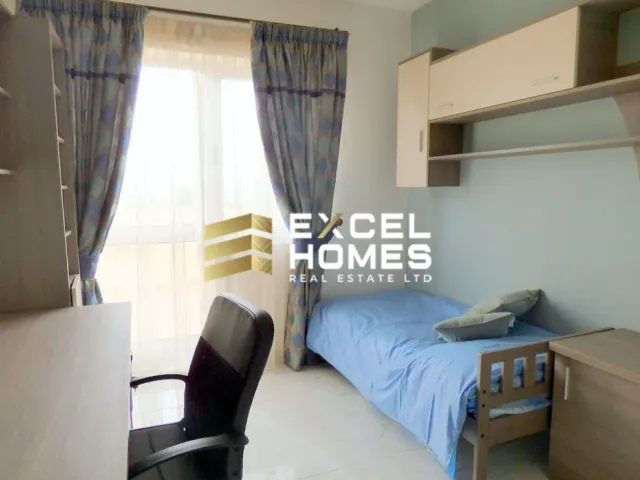a bedroom with a bed, desk, and chair 
