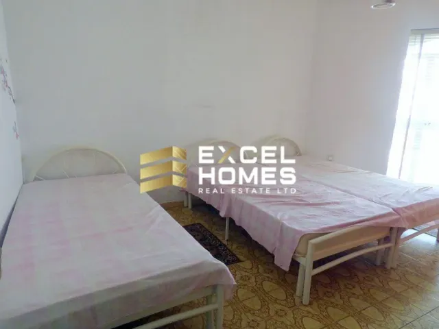 a bedroom with a bed, desk, and a window