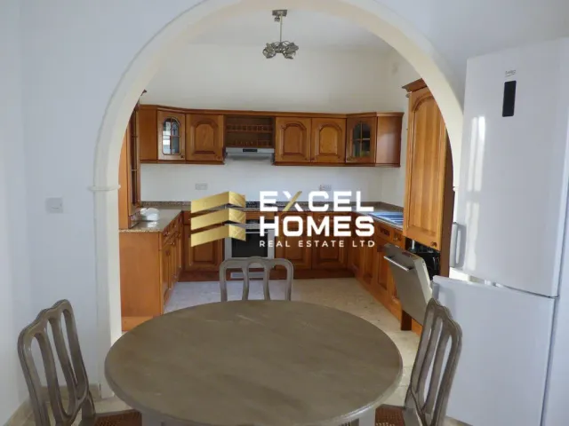 a kitchen with a table and chairs and a refrigerator 