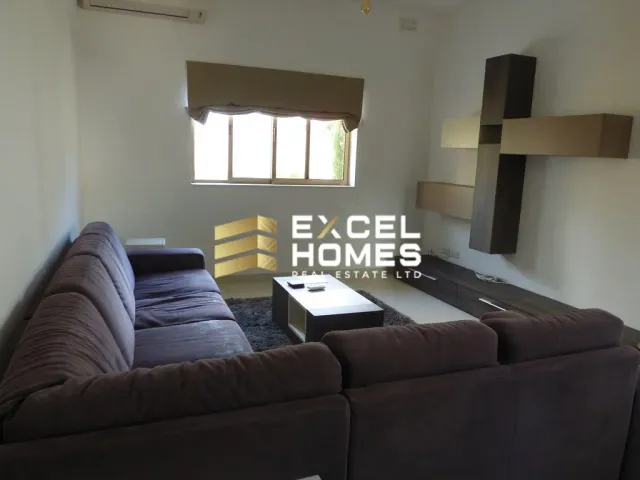 a living room with a couch, coffee table and a laptop 