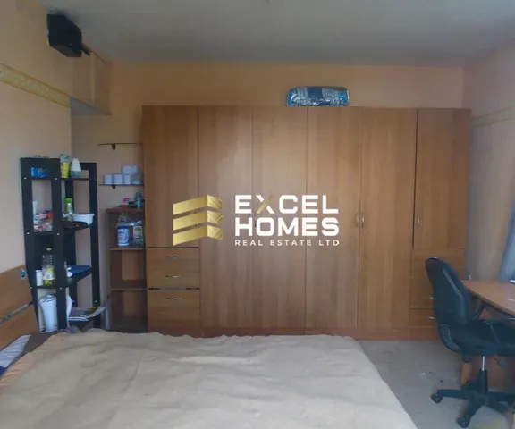 a room with a bed, desk, and a chair