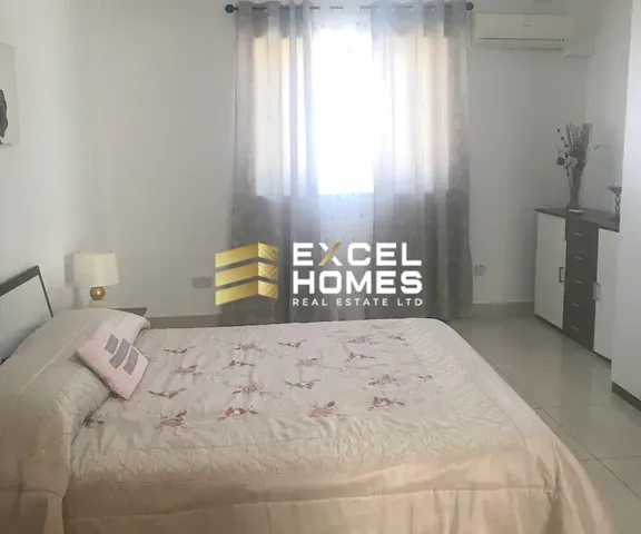 a bed with a white bedspread and a white wall