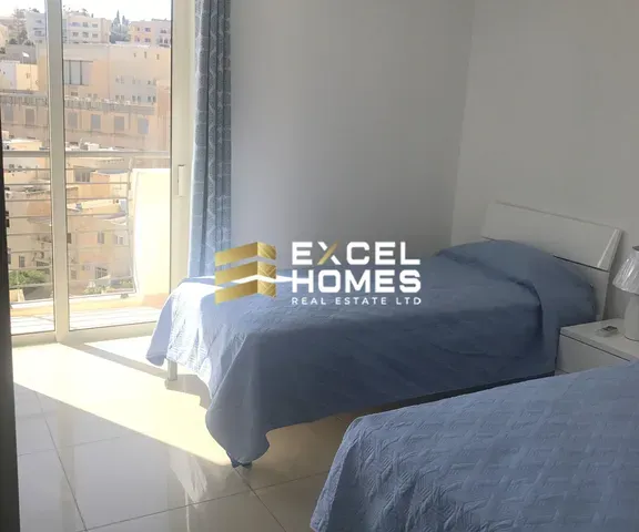 a bed with a blue blanket and a window