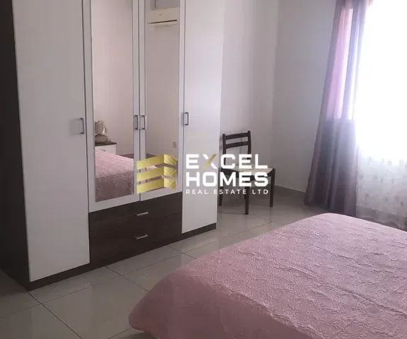 a bedroom with a bed, dresser, and a window